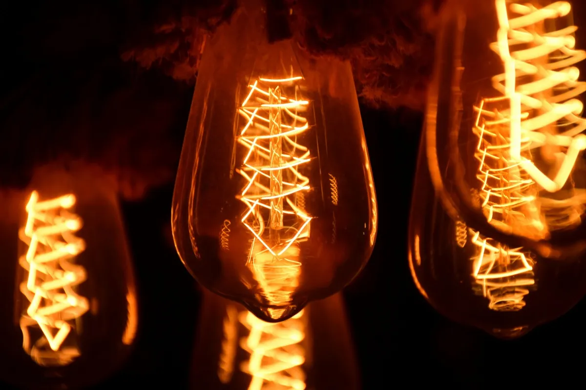 Incandescent light bulbs with their tungsten filaments glowing.